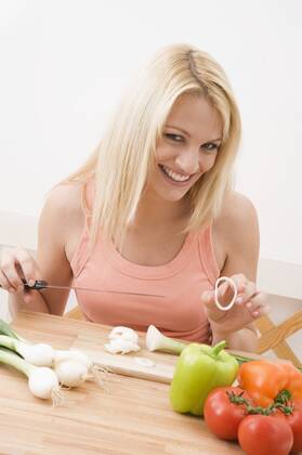 Woman slicing vegetables in the kitchen Woman slicing vegetables in kitchen
