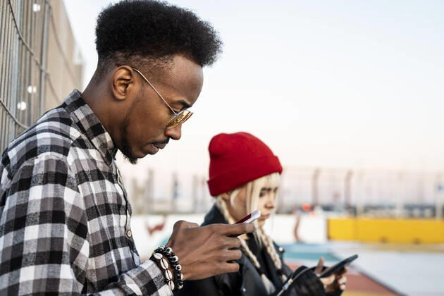 Young man using smartphone outdoors model released Symbolfoto  RCPF00205