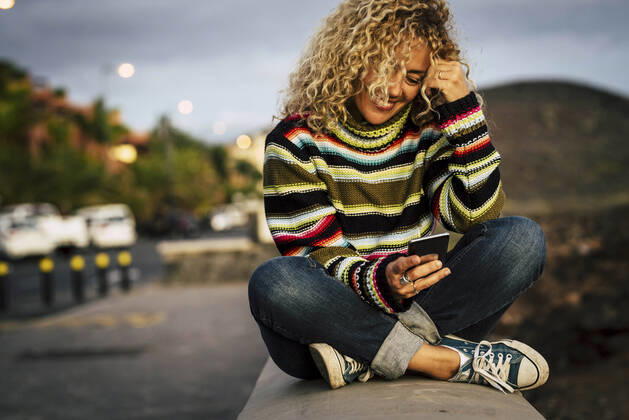 Portrait of woman wearing colorful pullover and using smartphone, Tenerife, Spain model released Symbolfoto  SIPF02106