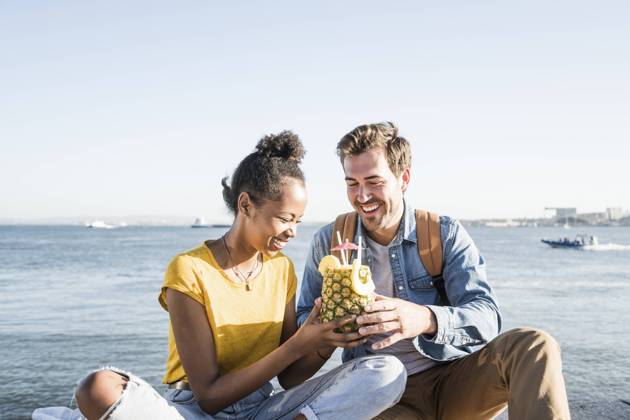 Happy young couple sitting at the waterfront sharing a drink in a pineapple, Lisbon, Portugal model released Symbolfoto  UUF19849