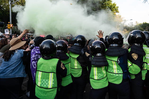 January 25, 2020, Mexico City, Distrito Federal, Mexico: Female police officers attempt to hold back activists while spraying green gas during the march..Hundreds of women attended the first feminist march of 2020 in Mexico City surrounded by hundreds of female police officers. The women used paint, fire to threaten police and men who came close to them. The women were campaigning for change in Mexico. The march was for female activists who had been assassinated, specifically Isabel Cabanillas and Yunuen L pez S¡nchez. Mexico City Mexico - ZUMAs197 20200125_zab_s197_023 Copyright: xLexiexHarrison-Crippsx