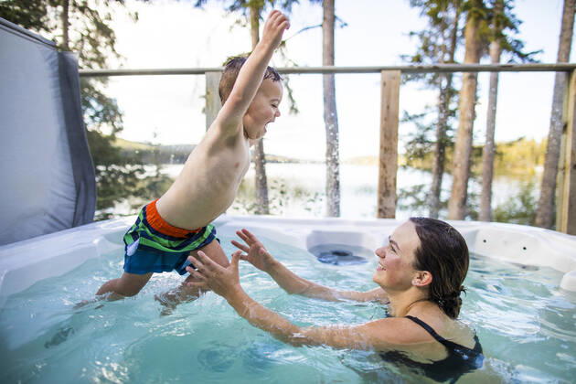 young boy jumping to mother in hot tub during vacation. Lac Le Jeune, BC, Canada CR_JDIP200102-245326-01