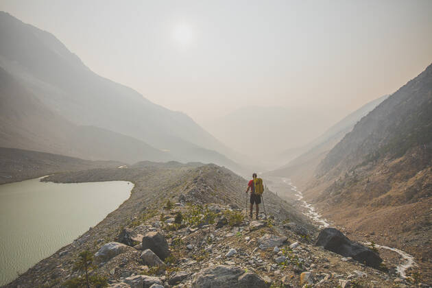 IMAGO Creative: Klimawandel - Nachhaltiges Reisen Backpacker hiking through valley filled with thick smoke. Pemberton, BC, Canada CR_JDIP200102-245515-01
