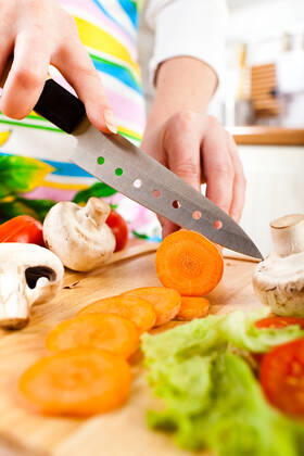 Woman s hands cutting vegetables Woman s hands cutting carrot, behind fresh vegetables.  Copyright: xcookelmax 1617150