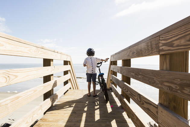 IMAGO Creative: Sommer Sport - Strand 6 year old boy on wooden bridge with his bike 6 year old boy on wooden bridge with his bike,St Simon s Island  61037