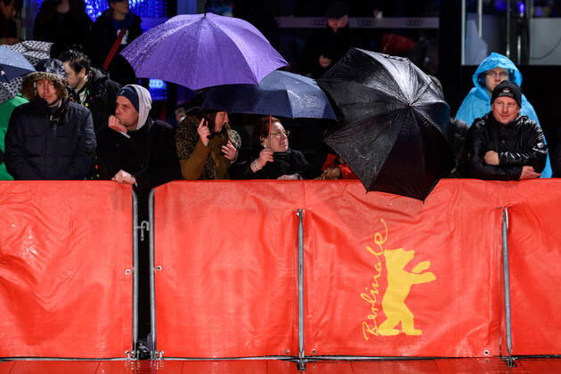 Fans under umbrellas in the rain during the premiere of the film SIBERIA at the 70th Berlin International Film Festival snapshot photography xF Boillot