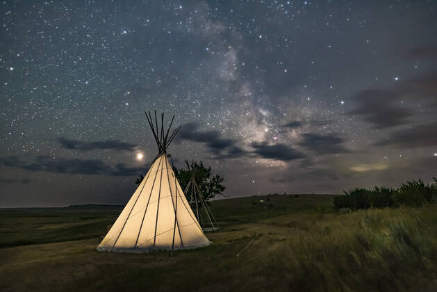 Mars (at left) and the Milky Way (at right) over a single tipi (with another under construction at back) at the Two Trees site at Grasslands National Park, Saskatchewan, August 6, 2018. I placed a low-level warm LED light inside the tipi for the illumination. This is a stack of 6 exposures, mean combined to smooth noise, for the ground, and one untracked exposure for the sky, all 30 seconds at f 2.2 with the 20mm Sigma lens and Nikon D750 at ISO 3200. Alberta Canada Copyright: xAlanxDyerx xVWPicsx ADY-OCT18-246