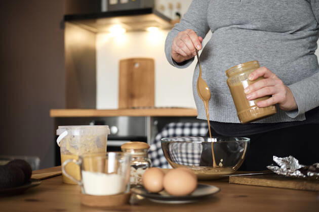 Pregnant woman making healthy cake with tahini, walnuts and dark chocolate at home model released Symbolfoto property released  BZF00513