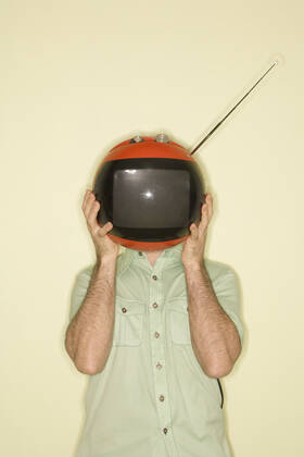 TV over man s head. Caucasian mid-adult man holding round red retro television in place of head.  Copyright: xiofotox 41016