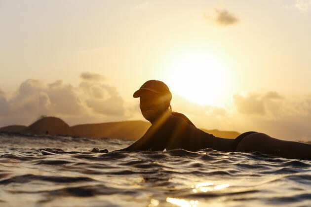 Female surfer lying on surfboard in the evening Lombok, Nusa Tenggara Bar., Indonesia ,model released, Symbolfoto CR_KOTRIN200120S-290423-01