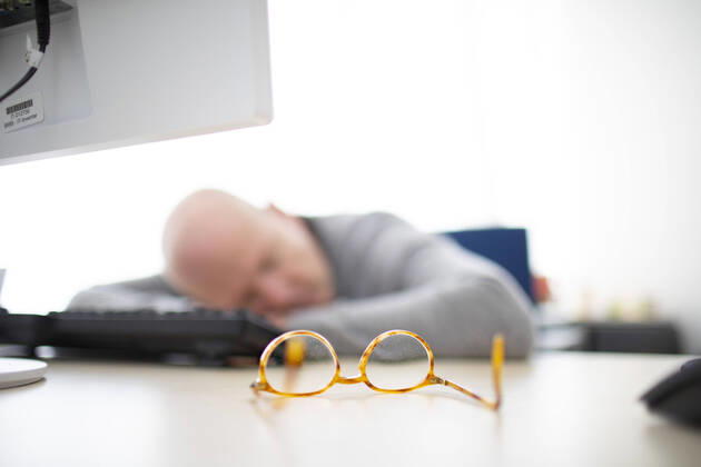 Photo presented on the subject of naps in the office, Bonn, den 11 03 2020 A man has taken off his glasses and is sleeping at his desk Bonn Germany Copyright: xUtexGrabowsky photothek.netx