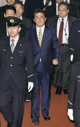 Japan PM Abe Japanese Prime Minister Shinzo Abe (C) heads to a session of the House of Councillors Budget Committee in Tokyo on March 16, 2020.