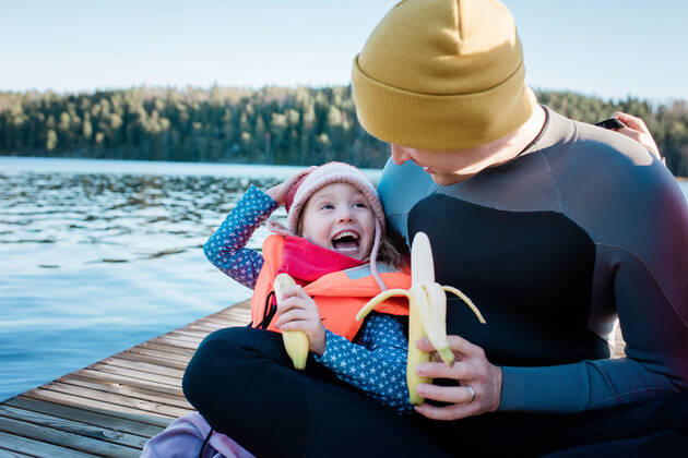 IMAGO Creative, Jahreszeit Sommer, Sommerferien father and daughter eating fruit laughing at the beach on vacation NorrtoÂ¤lje, Stockholm County, Sweden ,model released, Symbolfoto CR_RABE200224-308721-01