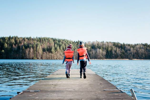 IMAGO Creative, Jahreszeit Sommer, Sommerferien brother and sister walking along a pier in winter with life vests on NorrtoÂ¤lje, Stockholm County, Sweden ,model released, Symbolfoto CR_RABE200224-308739-01