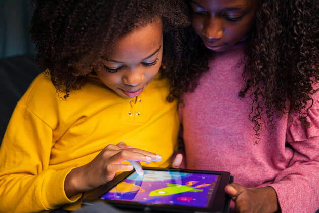 Sisters playing video game on digital tablet at home New York, NY, United States ,model released, Symbolfoto CR_LIWEEE200227-318408-01