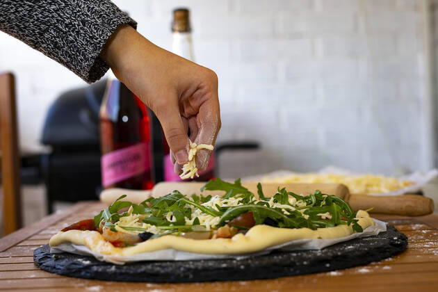 Hand throwing cheese into a vegetarian pizza. Barcelona, CT, Spain ,model released, Symbolfoto CR_EAFU200302A-318044-01