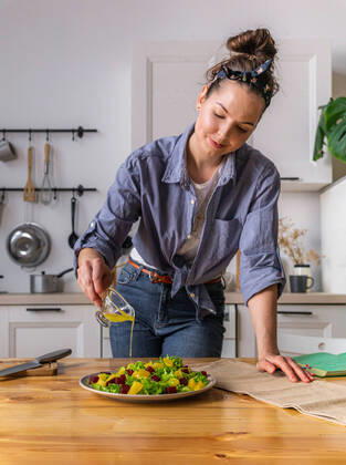Young and beautiful housewife woman cooking in a white kitchen Krasnodar, Krasnodar Krai, Russia ,model released, Symbolfoto CR_EVUV200313-320691-01