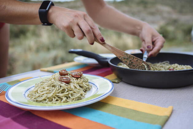 Close up of woman s hands preparing pasta with pesto during a trip. BooÂ­, CT, Spain ,model released, Symbolfoto CR_SCLO200323B-320057-01