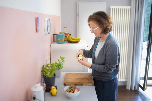 Woman standing in the kitchen cutting an apple Bonn Germany Copyright: xUtexGrabowsky photothek.netx