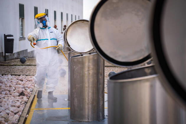 April 14, 2020, Ericeira, Portugal: An employee of the Ericeira parish council, equipped with the recommended protective materials, disinfects the recycling tanks with a solution based on hypochlorite (bleach)..The municipality of Mafra had 70 cases of COVID-19 pandemic. In order to prevent the spread of the virus, the Ericeira Parish Council perform weekly street disinfection. Ericeira Portugal - ZUMAs197 20200414_zaa_s197_172 Copyright: xHenriquexCasinhasx