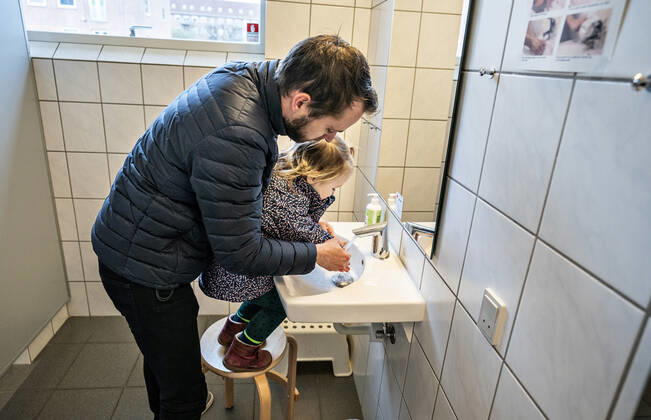 The nursery DUI in Aalborg opens again for the institutions children, Wednesday morning, April 15, 2020 Solvej wash hands with his father Due to the corona crisis, the nursery has been closed, and after the nursery has been changed inside and outside the children and the adult educators can hold distance and washing hands, Aalborg Jutland Denmark,  Copyright: HenningxBagger HenningxBaggerx COP102 spdk20200415-075936-L