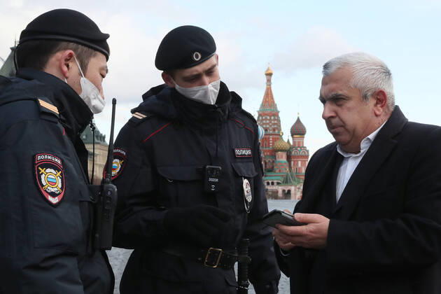 MOSCOW, RUSSIA - APRIL 15, 2020: Police officers check a man s documents in Red Square. Since 30 March 2020, Moscow has been on lockdown. Earlier, the Russian government announced a paid period off work for employed people and school holidays, which are expected to last till the end of April. On 13 April 2020, the Moscow government introduced a digital permit system aimed at further movement restrictions; from April 15, people need to apply for digital permits to travel on public transport or a personal vehicle around the city. As of 15 April 2020, Russia has reported more 24,500 confirmed cases of the novel coronavirus infection, with more than 14,800 confirmed cases in Moscow. Sergei Savostyanov TASS TS0D5E45