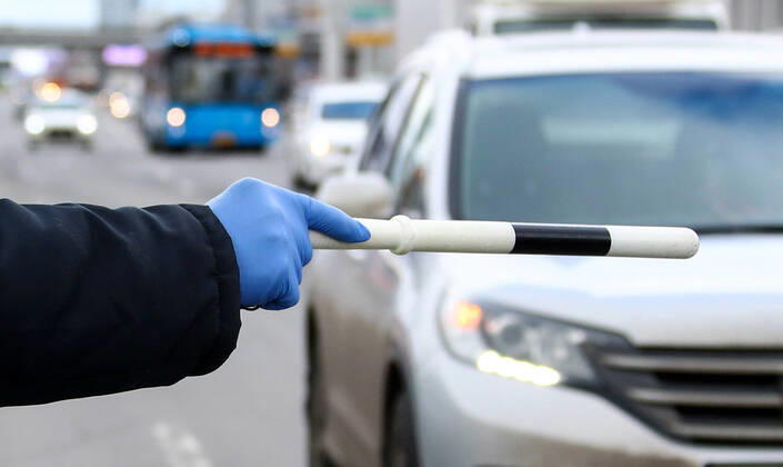 MOSCOW, RUSSIA - APRIL 15, 2020: A traffic police officer carries out ID checks on Leningradskoye Shosse Motorway at the entrance to Moscow during the pandemic of the novel coronavirus disease (COVID-19). Traffic police have set up checkpoints around the city to stop vehicles and see if drivers have permission to travel during the lockdown. On 13 April 2020, the Moscow government introduced a digital permit system aimed at further restricting movement. Under the new scheme, which becomes mandatory from 15 April, people need to apply for permits to travel on a vehicle or public transport around the city. Earlier, on 11 April, the Moscow government restricted vehicles registered outside Moscow Region from entering the Russian capital. Since 30 March 2020, Moscow has been on lockdown. As of 15 April 2020, Russia has reported more than 21,100 TS0D5D53