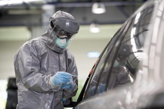 April 15, 2020, Granada, Spain: A health worker in a protective suit takes a sample for a PCR test..During the coronavirus crisis, at the ITV (technical inspection of vehicles) center in Albolote PCR tests (polymerase chain reaction) are carried out on workers of the security forces and staff of nursing homes to detect Covid 19. Granada Spain - ZUMAs197 20200415_zaa_s197_103 Copyright: xCarlosxGilx