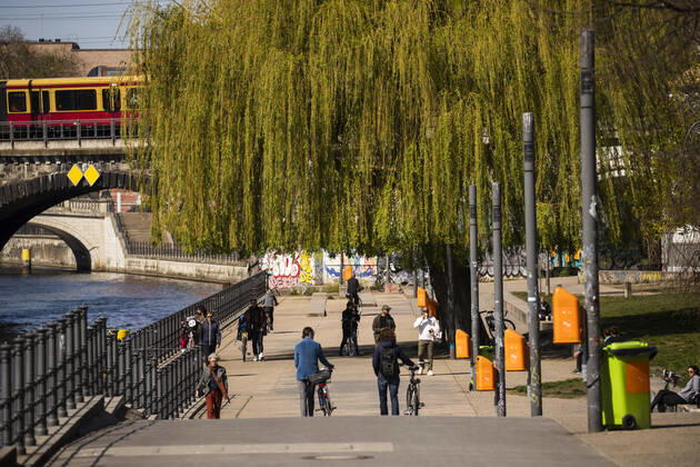 People walking in the sun on the banks of the Spree in Berlin on April 16, 2020 The measures decided by the federal and state governments to slow down the spread of the coronavirus SARS CoV 2 will continue before Easter The debate about compulsory mouth protection and the effectiveness of masks continues in the public eye Coronavirus in Berlin