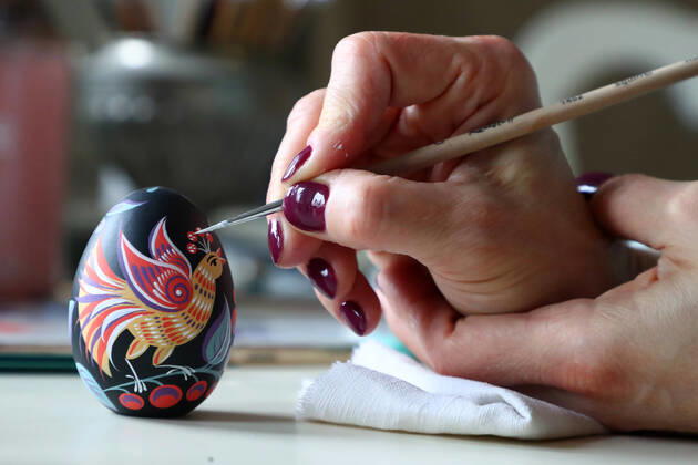 MOSCOW, RUSSIA - APRIL 16, 2020: Artist Iya Tokareva paints a wooden Easter egg Gorodets-style at her home studio; Gorodets painting, one of the traditional Russians handicrafts, originated in the middle of XIX century in the town of Gorodets, the Nizhny Novgorod Region. Anton Novoderezhkin TASS  TS0D5FDA