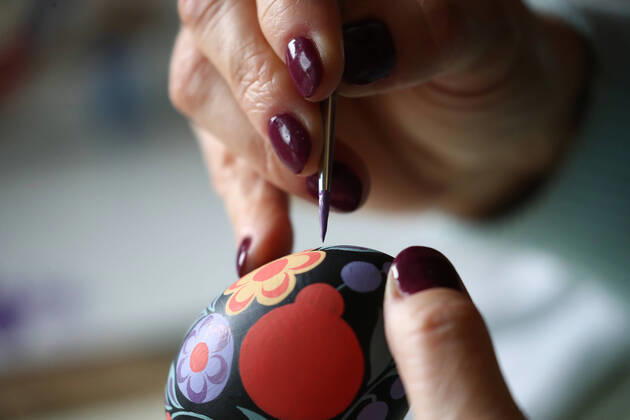 MOSCOW, RUSSIA - APRIL 16, 2020: Artist Iya Tokareva paints a wooden Easter egg Gorodets-style at her home studio; Gorodets painting, one of the traditional Russians handicrafts, originated in the middle of XIX century in the town of Gorodets, the Nizhny Novgorod Region. Anton Novoderezhkin TASS  TS0D5FE3