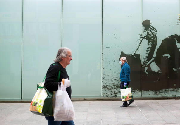 April 16, 2020, Malaga, Spain: An elderly man wearing a face mask as a preventive measure, walking past a mural of bullfighting during the covid-19 crisis..Following the confinement decreed by the Spanish government and will extended until 10th May, people are confinement in their homes causing an exceptional situation of unusual urban scenes such as empty streets. Malaga Spain - ZUMAs197 20200416_zaa_s197_043 Copyright: xJesusxMeridax