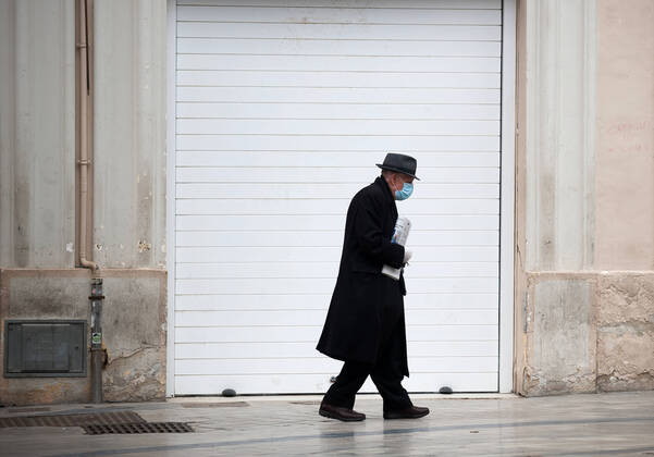 April 16, 2020, Malaga, Spain: An elderly man wearing a face mask walking past a closed store during the covid-19 crisis..Following the confinement decreed by the Spanish government and will extended until 10th May, people are confinement in their homes causing an exceptional situation of unusual urban scenes such as empty streets. Malaga Spain - ZUMAs197 20200416_zaa_s197_049 Copyright: xJesusxMeridax