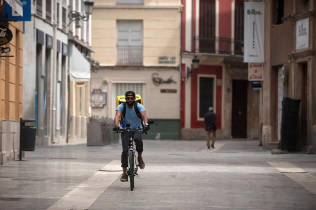 April 16, 2020, Malaga, Spain: A Glovo delivery man rides his bike along an empty street during the covid-19 crisis..Following the confinement decreed by the Spanish government and will extended until 10th May, people are confinement in their homes causing an exceptional situation of unusual urban scenes such as empty streets. Malaga Spain - ZUMAs197 20200416_zaa_s197_056 Copyright: xJesusxMeridax