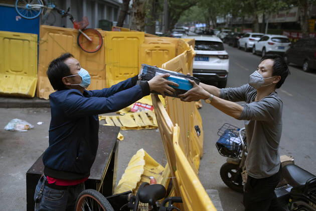 (200417) -- WUHAN, April 17, 2020 -- A man hands over a package to a deliveryman (R) in Wuhan, capital of central China s Hubei Province, April 16, 2020. As the coronavirus epidemic wanes, life returns to normal in Wuhan gradually. ) CHINA-WUHAN-DAILY LIFE-RETURNING TO NORMAL(CN) ShenxBohan 