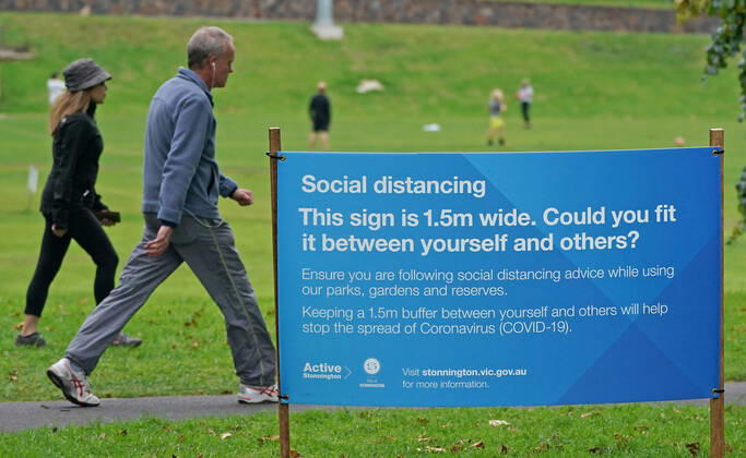 AUSTRALIA CORONAVIRUS COVID-19, People exercise at a park which displays social distancing signage in Melbourne, Saturday, April 18, 2020. Authorities have said social distancing and isolation measures could still remain in place for the next six months. A shutdown of non-essential services is in effect Australia wide in a bid to slow the spread of the coronavirus (COVID-19) disease. ( NO ARCHIVING, EDITORIAL USE ONLY, NO USE IN BOOKS WITHOUT CONSENT MELBOURNE VIC AUSTRALIA  Copyright: xSCOTTxBARBOURx 20200418001464075402
