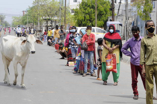 NEW DELHI, INDIA - APRIL 14: People queue to collect food distributed by Noida Authority, on April 14, 2020 in New Delhi, India. (Photo by Sunil Ghosh Hindustan Times ) Government And NGOs Provide Food To Homeless And Poor Amid Lockdown To Prevent Covid-19