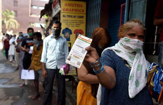MUMBAI, INDIA - APRIL 14: Residents of Dharavi lineup at rationing office for the food items, during the nationwide lockdown, imposed in the wake of the coronavirus pandemic, on April 14, 2020 in Mumbai, India. (Photo by Satish Bate Hindustan Times ) Government And NGOs Provide Food To Homeless And Poor Amid Lockdown To Prevent Covid-19