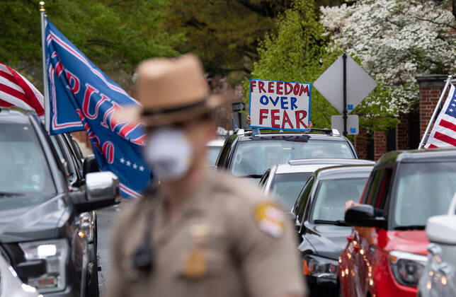 Drivers in vehicle participate in a car protest to reopen Maryland and end the stay at home order imposed during the Coronavirus COVID-19 pandemic, near the state capitol building in Annapolis, Maryland on Saturday, April 18, 2020. Drivers circled Annapolis hoking their horns and calling for Gov. Larry Hogan (R-MD) to end the stay at home order.  WAP20200418333 KEVINxDIETSCH