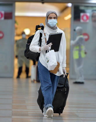 (200419) -- FARWANIYA GOVERNORATE, April 19, 2020 -- A Kuwaiti passenger walks out of the arrival hall of airport after she was evacuated from abroad, at Kuwait International Airport in Farwaniya Governorate, Kuwait, April 19, 2020. Kuwait launched on Sunday its major airlift to bring home Kuwaitis stranded abroad due to the coronavirus pandemic. (Photo by Xinhua) KUWAIT-FARWANIYA GOVERNORATE-COVID-19-AIRPORT-REPATRIATION Asad 