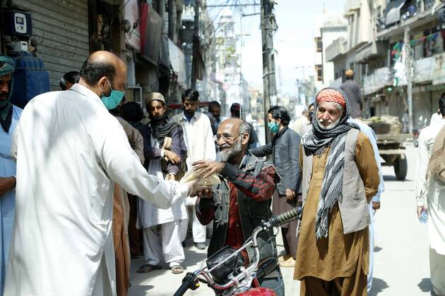 (200419) -- RAWALPINDI, April 19, 2020 -- A man distributes charity food among people in Rawalpindi of eastern Pakistan s Punjab province on April 19, 2020. ) PAKISTAN-RAWALPINDI-COVID-19-DAILY LIFE AhmadxKamal 