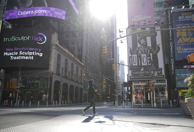 A pedestrian wearing a protective face walks in a nearly empty of pedestrian and automobile traffic Times Square on Easter Sunday of Orthodox Easter weekend in New York City on Sunday, April 19, 2020. The world s Orthodox Christians are celebrating Easter through a series of restrictions and bans including closures of churches due to the Coronavirus pandemic. More than 13,300 people with COVID-19 have died in New York State.  NYP20200419112 JOHNxANGELILLO
