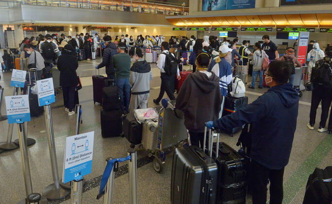 Hundreds of passengers form a line to check-in and board a China Southern Airlines midnight flight to China on Sunday, April 19, 2020 in Los Angeles. Passengers at the front of the line arrived at 5:30 a.m., with many others standing in line since 8 a.m. to ensure they would have a seat before the plane was full. Mayor Eric Garcetti said 95% of air travel has stopped in his city as Los Angeles sees the biggest drop of airplane travel in LAX history.  LAP2020041921 JIMxRUYMEN