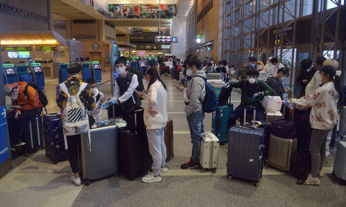 Hundreds of passengers form a line to check-in and board a China Southern Airlines midnight flight to China on Sunday, April 19, 2020 in Los Angeles. Passengers at the front of the line arrived at 5:30 a.m., with many others standing in line since 8 a.m. to ensure they would have a seat before the plane was full. Mayor Eric Garcetti said 95% of air travel has stopped in his city as Los Angeles sees the biggest drop of airplane travel in LAX history.  LAP2020041906 JIMxRUYMEN