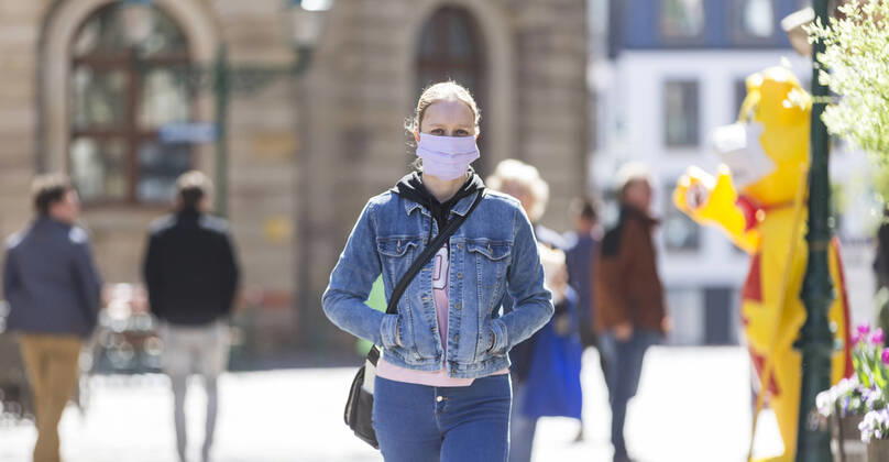 Germany, , , , 20 04 2020, Presse, COVID 19 Germany is slowly rising again Bild In Hesse, shops have reopened, in Bavaria they havent. This has a particular effect on the East Hessian city of Fulda, which is not far from the Bavarian border A woman walks through Fulda wearing a face mask Copyright: HMBxMedia OliverxMueller
