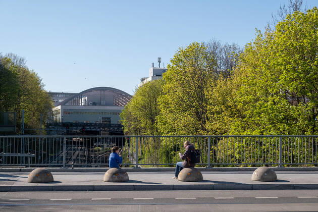 A mother treats herself to an ice cream on the Pappelalleebrücke in Berlin Coronakrise with her child, while observing the rules of distance