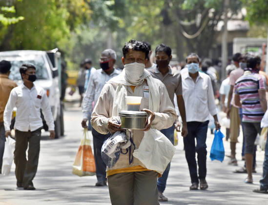 NEW DELHI, INDIA - APRIL 21: People queue to collect food distributed by BJP councilor Shikha Rai during lockdown to curb spread of coronavirus, at Shahpur Jat, on April 21, 2020 in New Delhi, India. (Photo by Sanjeev Verma Hindustan Times) Government And NGOs Provide Food To Homeless And Poor Amid Lockdown To Prevent Covid-19 Pandemic