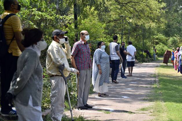 NEW DELHI, INDIA - APRIL 21: Residents look on during a PPE kit distribution drive for cleaning staff by Defence Colony welfare groups in association with SDMC during lockdown, at Defence Colony, on April 21, 2020 in New Delhi, India. (Photo by Sanjeev Verma Hindustan Times) PPE Kits Distributed To SDMC Sanitation Staff