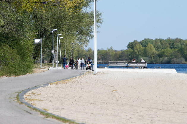 22 04 2020, xtgx, Consequences of the Corona Virus in Wolfsburg, Passers-by on the paths along the Allersee People are using the banks of the Allersee again to relax, go for a walk or do sports After a ban on entering the lake in recent weeks, this ban has now been lifted, but sunbathing or using the games and sports grounds is still prohibited Wolfsburg