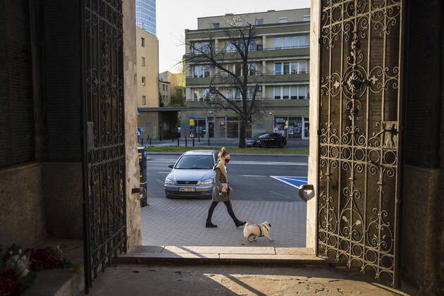 April 22, 2020, Warsaw, Mazowieckie, Poland: A woman wearing a face mask as a precaution while walking her dog during the Covid-19 pandemic..The Polish government softened some of the restrictions related to the Covid-19 pandemic. Citizens are now allowed to walk in parks, more customers are allowed to enter shops. Protective masks are still obligatory for every citizen in public space. Warsaw Poland - ZUMAs197 20200422_zaa_s197_106 Copyright: xAttilaxHusejnowx